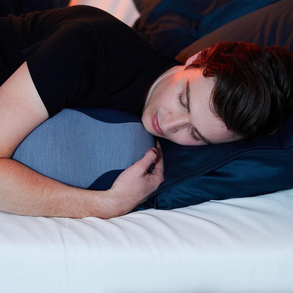 Man liggend in bed met de Somnox 2 Adem- & Slaaprobot