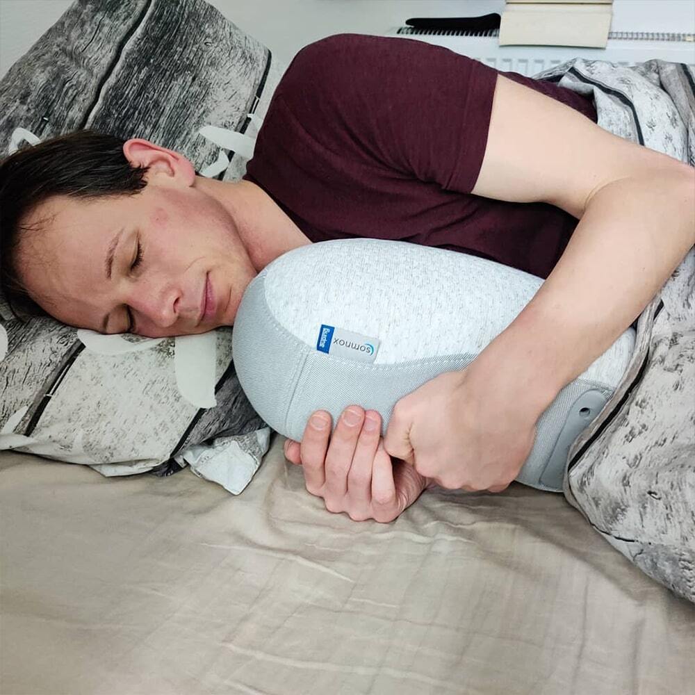 Man slapend in bed met de Somnox Slaaprobot
